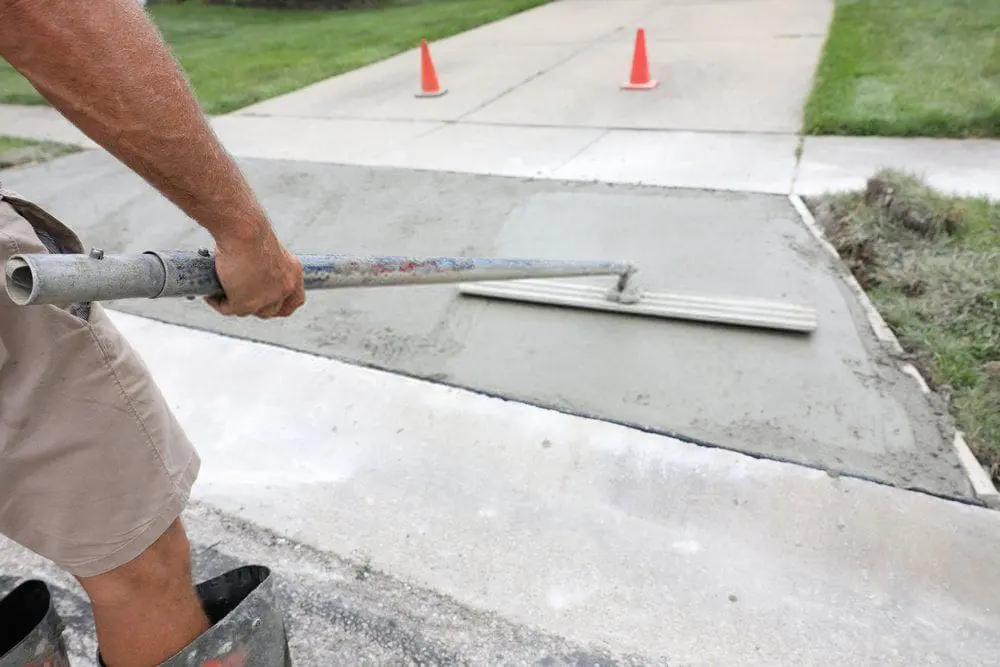 Dade Decorative Concrete pro leveling this Miami FL driveway surface with a horsehair broom